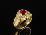 a close up of a gold ring with a ruby stone