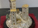 statue of a castle on a rock with a tree in front of it