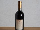 a bottle of wine sitting on a table next to a bottle of wine