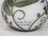 a white vase with a green leaf design on it