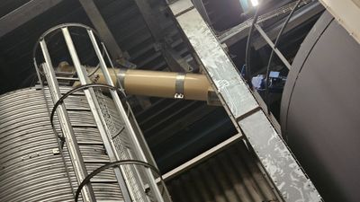 an image of a man standing on a ladder next to a large metal tank