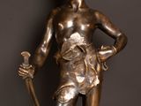 a bronze statue of a boy holding a sword and a dog