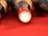 several bottles of wine are lined up on a red surface