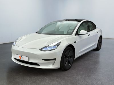 a white tesla model 3 parked in a white room