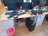a lot of computer monitors and keyboards on this desk