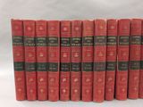 several red books are lined up in a row on a white surface
