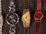 several different watches are lined up on a black surface