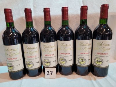 six bouteilles de vin rouge sont alignées sur une table