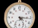 gros plan d'une montre de poche en or sur fond noir