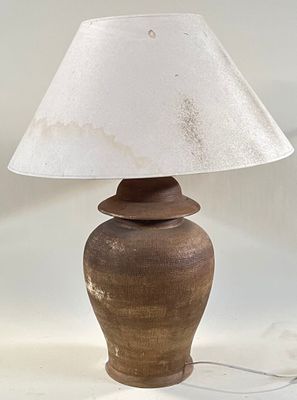 a lamp that is sitting on a table with a white shade on it