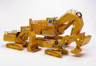 une maquette jaune d'un bulldozer et un bulldozer