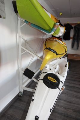 un kayak jaune et blanc posé sur un porte-kayaks