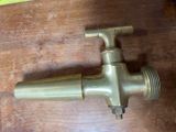 a brass faucet that is on a wooden table