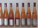 six bouteilles de vin sont alignées sur une table