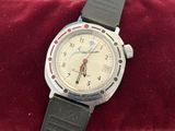 wrist watch sitting on a red velvet cushion on a table