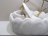 a white purse with a gold handle sitting on a shelf