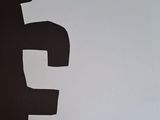 a white paper cut out of a letter f with a black background