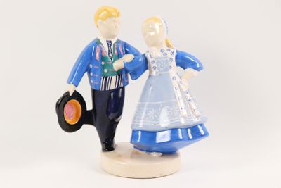 a figurine of a man and a woman holding a vinyl record