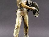 statue en bronze représentant un homme tenant un chapeau et un gant de baseball
