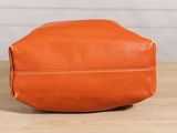 an orange leather toilet bag sitting on top of a wooden table
