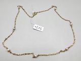 a gold chain bracelet with pearls and a tag on it