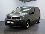 La camionnette grise est garée dans la grande salle de l'immeuble.