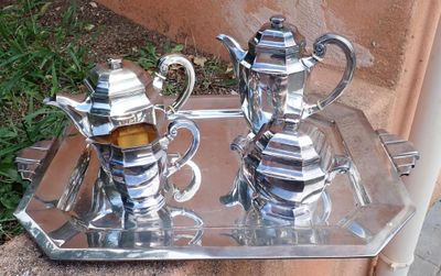 deux théières en argent posées sur un plateau en argent, par terre
