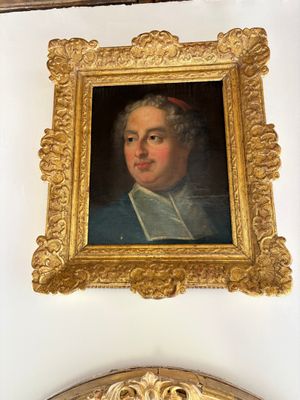 a painting of a man in a gold frame on the wall