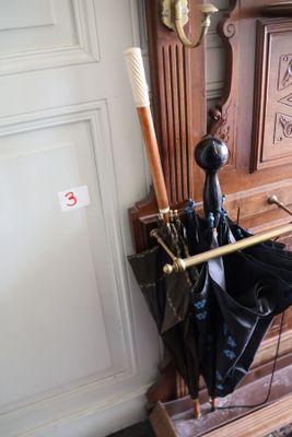 un banc en bois sur lequel sont posés plusieurs parapluies