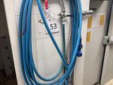 un tuyau bleu fixé au mur dans des toilettes publiques