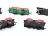 four miniature trains that are sitting on a white surface