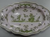 a green and white plate with a picture of a boat on it