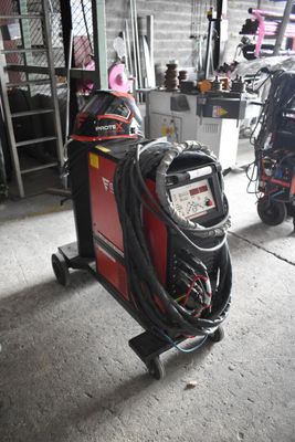une soudeuse dans un garage, à côté d'autres équipements