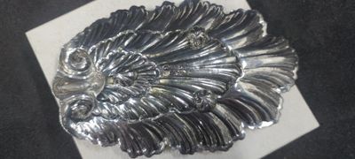 a silver brooch with a large feather on it