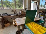 un établi au milieu d'une pièce, sur lequel sont posés de nombreux outils