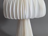 a white mushroom shaped object made out of folded paper