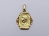 Gros plan sur un pendentif en or orné d'un visage de femme
