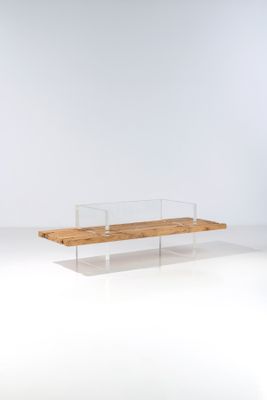 un banc en acrylique, composé de bois et de verre, posé sur une surface blanche