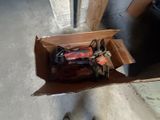 une boîte en carton posée par terre, contenant des outils