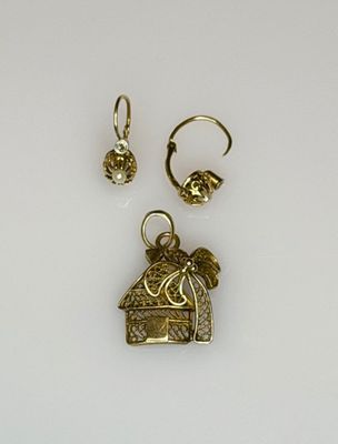 two gold earrings and a ring with a bird on it