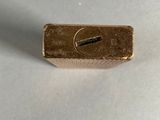 a small piece of gold on a white surface