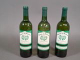 trois bouteilles de vin posées l'une à côté de l'autre sur une table