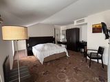 a room with a bed, desk, chair, and television in it