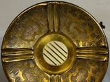 brass plate with decorative design on it on a white surface