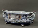 un grand bol bleu et blanc orné d'une statuette