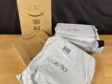 a box with a pair of white t - shirts sitting on top of a wooden table