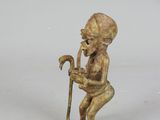 an antique bronze figurine of a boy with a cane