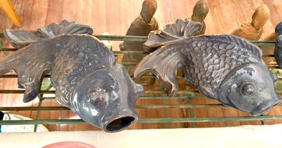 deux poissons posés sur une étagère à côté d'une bouteille de vin