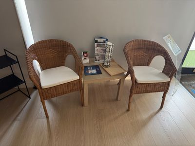 deux fauteuils en osier et une petite table dans une pièce