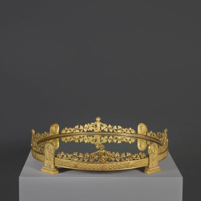 une couronne en or posée sur un socle blanc, sur fond noir